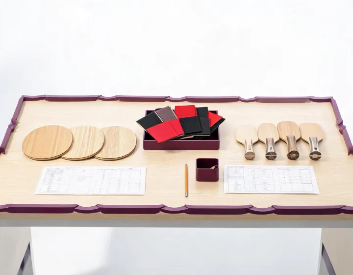 Buyer reviewing custom table tennis paddle specifications beside blade and rubber samples